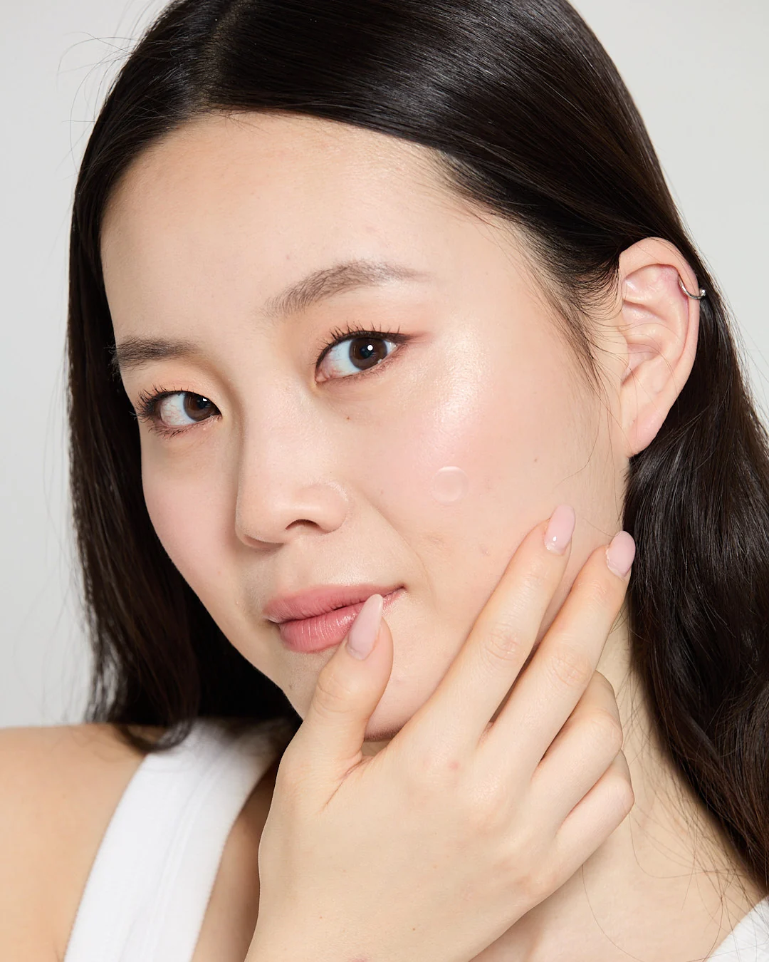Halo Dot model wearing a discreet clear pimple patch on her cheek