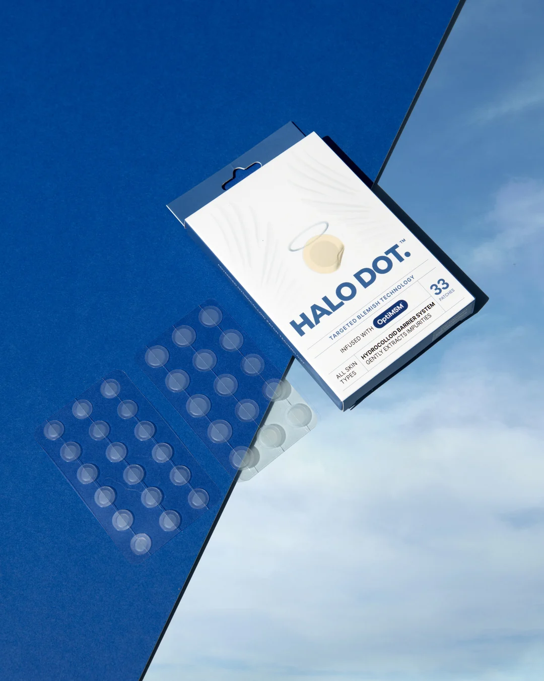 Halo Dot pimple patch packaging and clear patches on a blue background